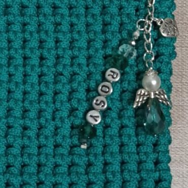 Charm in perline con angelo su una custodia verde all’uncinetto